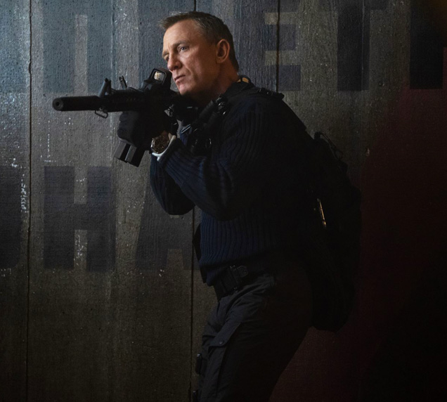 photo © Danjaq LLC, MGM, United Artists James Bond (Daniel Craig) in No Time To Die, wearing his commando outfit and tactical sling bag.