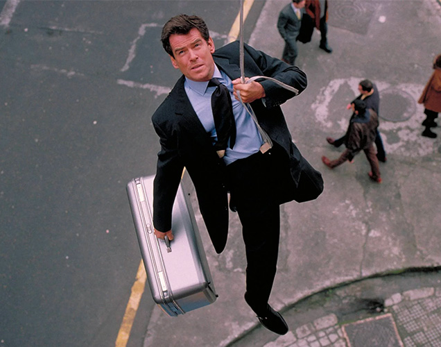 photo © Danjaq LLC, MGM, United Artists Pierce Brosnan in The World Is Not Enough, wearing a Church's Presley shoes, Brioni suit, a Turnbull & Asser tie and holding a Samsonite case.