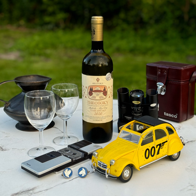 photo © Bond Lifestyle A modern bottle of Theotoky white wine, surrounded by Bond lifestyle items from the Corfu scenes.