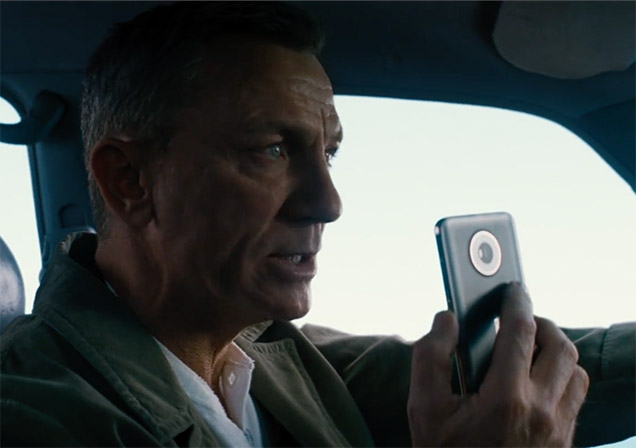 photo © Danjaq LLC, MGM, United Artists Daniel Craig as James Bond using the Nokia phone in No Time To Die while driving the Toyota Land Cruiser 90 Series.
