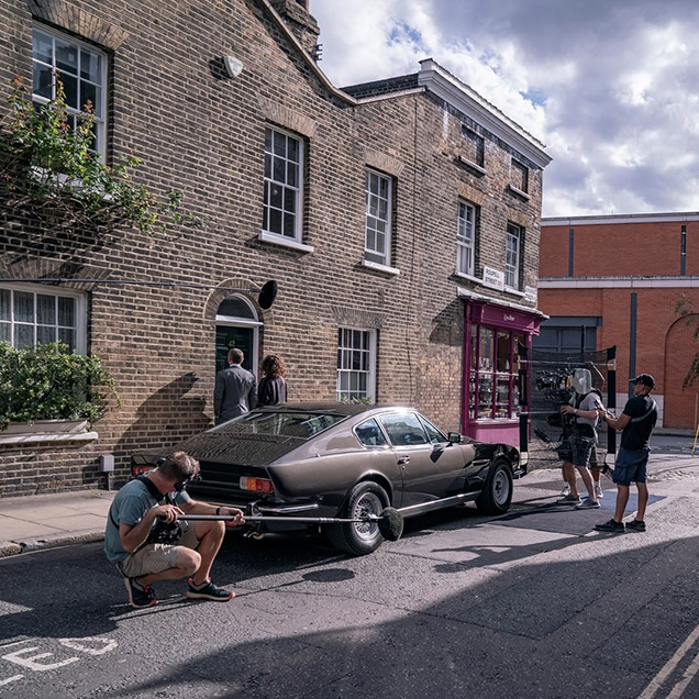 photo © Danjaq LLC, MGM James Bond and Moneypenny and the Aston Martin V8 on the streets of London during filming of No Time To Die.